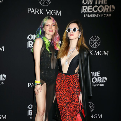 Bella Thorne, 21, leaves little to the imagination in extreme plunging dress as she joins lookalike sister Dani, 26